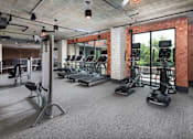 Thumbnail 31 of 46 - a gym with treadmills and other exercise equipment in a room with glass windows