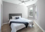 Thumbnail 18 of 32 - a bedroom with a large bed and a ceiling fan