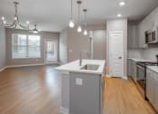 Thumbnail 15 of 32 - an open kitchen and living room with an island and a sink
