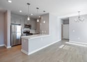 Thumbnail 13 of 32 - an empty kitchen and living room with a stainless steel refrigerator