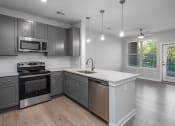 Thumbnail 10 of 32 - an empty kitchen with stainless steel appliances and a white counter top