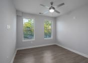 Thumbnail 17 of 32 - an empty room with a ceiling fan and two windows
