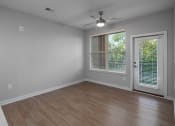 Thumbnail 16 of 32 - an empty living room with a window and a ceiling fan