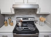 Thumbnail 3 of 16 - a small kitchen with a stove and a kettle on it