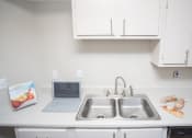 Thumbnail 5 of 16 - a kitchen with a sink and a laptop computer on the counter