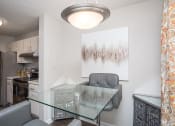 Thumbnail 6 of 16 - a dining room with a glass table and chairs and a kitchen