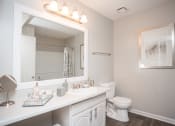 Thumbnail 12 of 16 - a bathroom with a large mirror and a toilet and sink