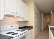 Thumbnail 15 of 30 - a long hallway with white cabinets and black and white floors