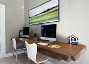 Thumbnail 6 of 31 - a home office with a desk with two computers and a large monitor on the wall