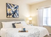 Thumbnail 15 of 31 - a bedroom with a white bed and a painting on the wall
