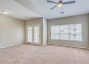 Thumbnail 13 of 29 - an empty living room with a ceiling fan and a window
