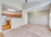 Thumbnail 12 of 29 - the living room and kitchen of an empty house with a carpeted floor