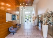 Thumbnail 3 of 35 - the lobby of a condo building with a lobby area with chairs and a tv