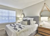 Thumbnail 12 of 27 - a bedroom with a large window and a large bed with a white comforter and pill  at Crestmont at Thornblade, Greenville
