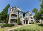 Thumbnail 34 of 38 - an apartment building with green grass and trees