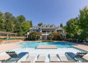 Thumbnail 25 of 38 - a swimming pool with chairs around it and a house in the background