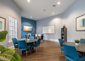 Thumbnail 4 of 30 - A dining room with blue chairs and a wooden table.