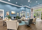 Thumbnail 3 of 30 - A room with blue walls and wooden floors has a large table surrounded by chairs.