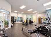 Thumbnail 8 of 30 - A gym with treadmills, elliptical machines, and other exercise equipment.