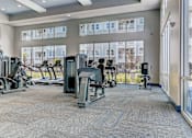 Thumbnail 8 of 31 - A gym with a variety of equipment including treadmills, stationary bikes, and weight machines.