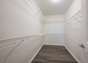 Thumbnail 17 of 35 - A walk in closet with a white door and shelves.