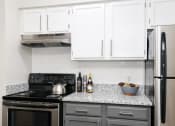Thumbnail 4 of 31 - a kitchen with white cabinets and black appliances and a granite counter top