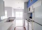 Thumbnail 13 of 31 - a kitchen with white cabinets and a sink and a refrigerator