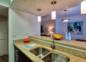 Thumbnail 6 of 35 - A kitchen with a sink and a bowl of fruit on the counter.