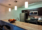 Thumbnail 5 of 35 - A kitchen with a bowl of fruit on the counter.