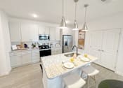 Thumbnail 11 of 23 - A kitchen with a table set for two with orange slices on the plates.