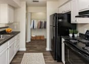 Thumbnail 1 of 30 - A kitchen with black appliances and white cabinets.