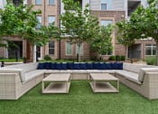 Thumbnail 35 of 41 - a patio with couches and tables in front of a brick building