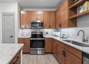 Thumbnail 22 of 41 - a kitchen with wooden cabinets and stainless steel appliances