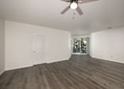 Thumbnail 12 of 35 - A room with a ceiling fan and wood flooring.