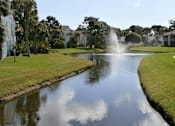 Thumbnail 12 of 21 - A resort-style community with lush landscaping and lake views at Lake in the Woods, Melbourne, FL