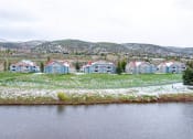 Thumbnail 16 of 20 - a group of colorful houses next to a body of water