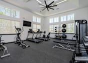 Thumbnail 40 of 49 - Louisville, KY, Luxury Apartments with Attached Garage - The Laurel Apartments - Fitness Center With Treadmills, Elliptical Machine, Weight Bench, Dumbbell Rack, Large Windows, And A Ceiling Fan.