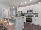 Thumbnail 5 of 49 - A kitchen with white cabinets and a granite countertop.