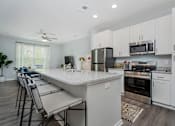 Thumbnail 4 of 49 - A kitchen with white cabinets and a marble countertop.