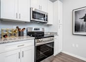 Thumbnail 6 of 49 - A modern kitchen with a stainless steel oven and microwave.