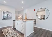 Thumbnail 11 of 49 - A modern kitchen with white cabinets and a large island.