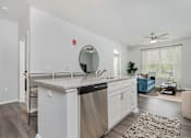 Thumbnail 7 of 49 - A modern kitchen with white cabinets and a large island.