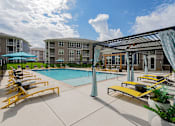Thumbnail 48 of 49 - Jeffersonville, IN Luxury Apartments With In-Unit Washer And Dryer - The Laurel - Outdoor Swimming Pool with Poolside Loungers, Pergola, Fence, and Views of Apartment Buildings.