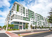 Thumbnail 18 of 18 - A modern multi-story building with a green vertical garden on the side.