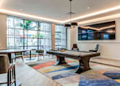 Thumbnail 15 of 18 - A room with a pool table and a television mounted on the wall.