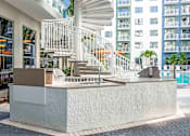 Thumbnail 3 of 18 - A white staircase with a metal railing is in front of a building.