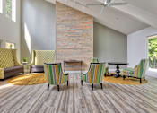 Thumbnail 3 of 35 - A living room with a brick wall and striped chairs.