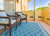 Thumbnail 17 of 34 - a balcony with two chairs and a rug at L'Estancia, Sarasota