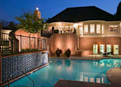 Thumbnail 25 of 33 - a swimming pool at night in front of a resort building