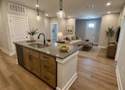 Thumbnail 6 of 11 - A kitchen with a large island and a dining area.